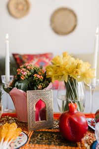 Vibrant Nowruz celebration table with candles, flowers, and traditional decor.